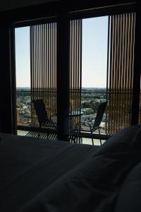 ein Schlafzimmer mit einem Bett und zwei Stühlen vor Fenstern in der Unterkunft Rois Constructions in Nikosia