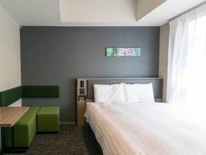 a hotel room with a bed and a table and a window at Comfort Hotel ERA Kyoto Toji in Kyoto +38 photos