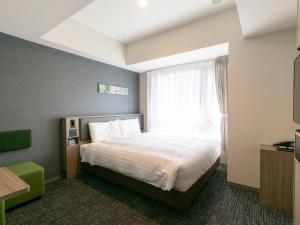 a hotel room with a bed and a window at Comfort Hotel ERA Kyoto Toji in Kyoto