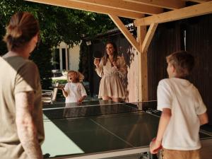 a woman and two children standing on a tennis court at Residence Montani in Laces