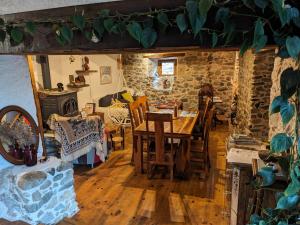 a dining room with a table and chairs and a stone wall at Chambres d'hôtes Les Chatougoulis in Les Bordes-sur-Lez +42 photos