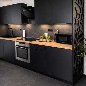 a kitchen with black cabinets and a counter top at Ferienhaus Schieferland in Müllenbach