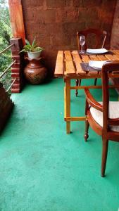 a wooden table with two chairs and a table with a glass at Padiwatte Residencies in Kandy