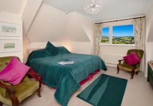 a bedroom with a bed and two chairs and a window at Halekulani Devon Homestay in Torquay +45 photos