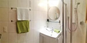 a bathroom with a sink and a shower with a mirror at Apart Hannah in Uderns +25 photos