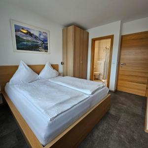 a bedroom with a large bed with white sheets at Apart Hannah in Uderns