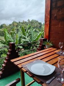 a wooden table with a white plate on a table at Padiwatte Residencies in Kandy