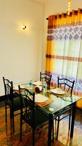 a dining room with a glass table and chairs at The Continental Hotel in Seeduwa