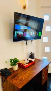 a tv hanging on a wall with a wooden desk at The Continental Hotel in Seeduwa