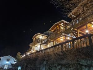 a large wooden house at night with lights at Goesan Joryeong Pension in Koesan