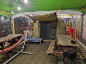 a tent with a table and a bench and a stage at Goesan Joryeong Pension in Koesan