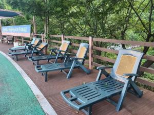 a row of blue lawn chairs sitting on a deck at Goesan Joryeong Pension in Koesan +147 photos