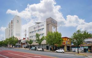 a building on the side of a street with cars parked at Daegu Brown Dot Hotel Kyungpook National University in Daegu