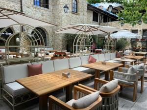 a restaurant with wooden tables and chairs and umbrellas at Castro Mesembria Boutique Hotel in Nesebar
