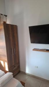 a bedroom with a cabinet and a tv on a wall at Casa de Playa Antawara in El Porvenir