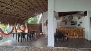 a dining room with tables and chairs and a kitchen at Casa de Playa Antawara in El Porvenir