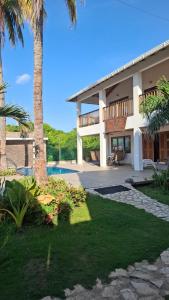 a villa with a swimming pool and palm trees at Casa de Playa Antawara in El Porvenir