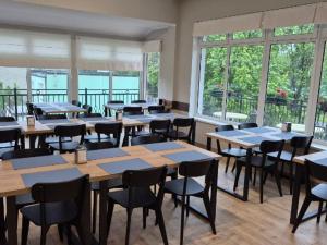 ein Esszimmer mit Tischen, Stühlen und Fenstern in der Unterkunft Hotel Kliper in Władysławowo