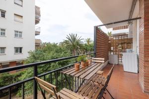 ein Balkon mit einem Holztisch und Bänken in der Unterkunft Melody in Sitges