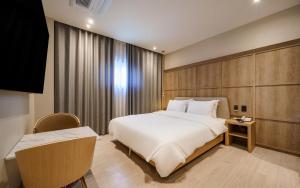 a bedroom with a large white bed and a desk at Daegu Brown Dot Hotel Kyungpook National University in Daegu +33 photos