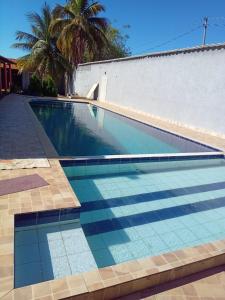 a swimming pool with a tile floor and a white wall at Aconchego do Peruaçu in Itacarambi +11 photos