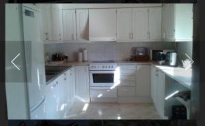 a white kitchen with white cabinets and an oven at Schwedentraum in Burseryd