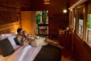 a man and a woman laying on a bed at Kaya Retreat in Diyatalawa