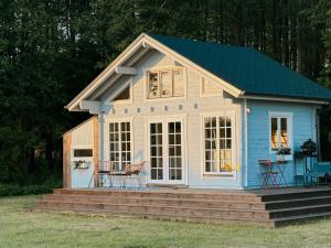 a tiny house with a porch and a deck at Mereäärne helesinine suvemaja in Tahkuranna