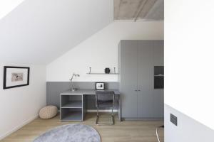 a white kitchen with a desk and a chair at Solo Society Hybrid Hotel Vilnius in Vilnius