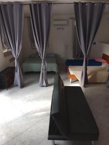 a room with two beds with curtains and a table at La casetta in Martina Franca