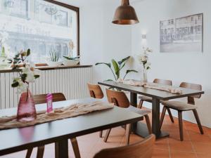 two tables and chairs in a room with flowers at MYA Weinland Hotel Kobern-Gondorf in Kobern-Gondorf