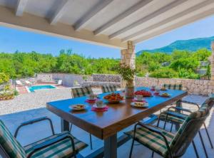 a table and chairs on a patio with a view at Rustic Haven Villa in Vrgorac