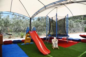 a playground with two swings and a slide at Kandia Woodlands in Kandia