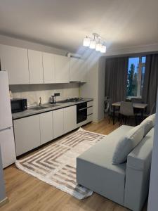 a living room with a white couch and a kitchen at Kogălniceanu 24 in Căuşeni +26 photos