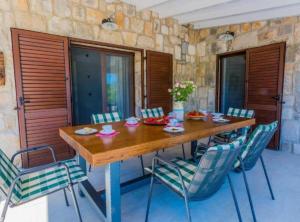 a dining room with a wooden table and chairs at Rustic Haven Villa in Vrgorac