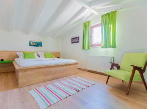 a bedroom with a bed and a green chair at Rustic Haven Villa in Vrgorac +39 photos