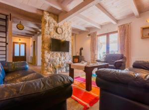 a living room with leather couches and a table at Rustic Haven Villa in Vrgorac