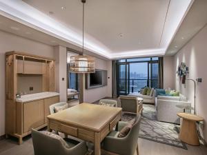 a dining room and living room with a table and chairs at Lebanshan Hotel Chongqing Yongle in Chongqing