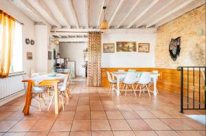a dining room with tables and white chairs at La Maison de la Colline in Vers