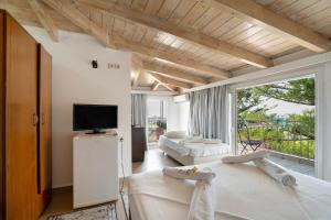 a living room with white furniture and a large window at Pigasos in Nikiana