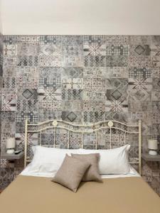 a bedroom with a bed and a wall with tiles at Lauro Apartment in Meta