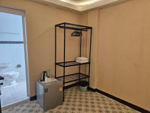 a bathroom with a toilet and a shelf with towels at Cozy rooms Asoke in Bangkok