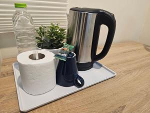 a coffee maker with a roll of toilet paper and a water bottle at Cozy rooms Asoke in Bangkok