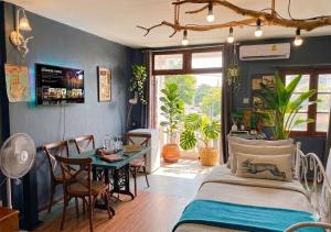 a bedroom with a bed and a table and chairs at Nego Home Ancient Inn in Bangkok