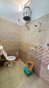 a bathroom with a toilet and a bucket in it at Kanak Bihari Enclave in Ayodhya