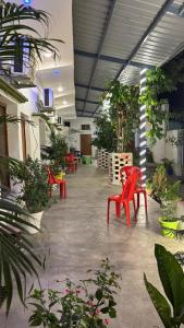 a room with red chairs and potted plants at Kanak Bihari Enclave in Ayodhya