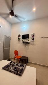 a room with a bed and a chair and a tv at Kanak Bihari Enclave in Ayodhya +41 photos
