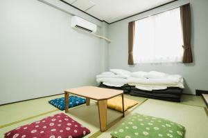 a room with a table and a pile of pillows at Portside Stay 石垣島 離島ターミナル徒歩3分 バスターミナル前 室内リニューアル in Ishigaki Island
