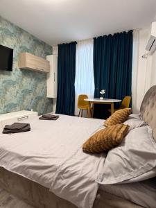 a bedroom with a large bed and a table at Happy Studio 1 in Craiova