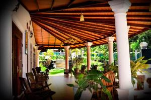 a porch with chairs and a wooden roof at The Kings Villa in Kandy